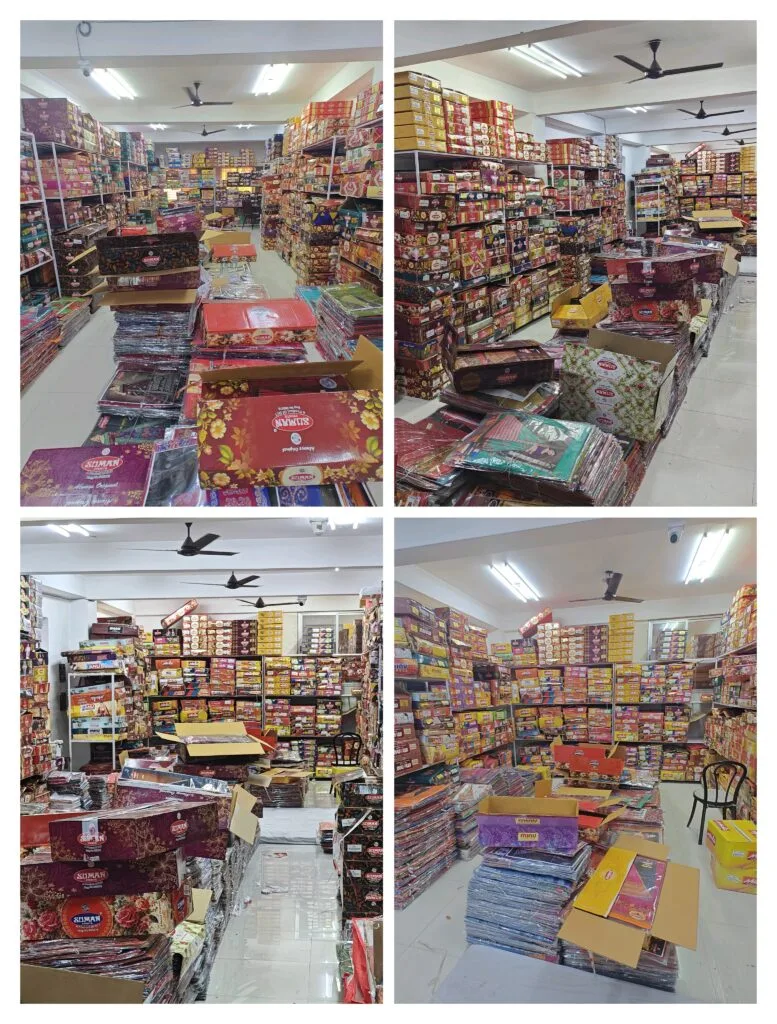 Wholesale inventory of boxed cotton sarees stacked floor-to-ceiling at Santosh Synthetics, Jamshedpur.